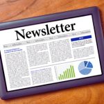 Tablet displaying a digital newsletter with text articles, a pie chart, and a bar graph. The layout suggests an informative and professional tone.